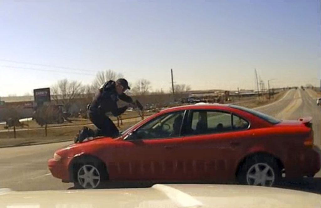 Iowa Police Officer On Hood Of Car