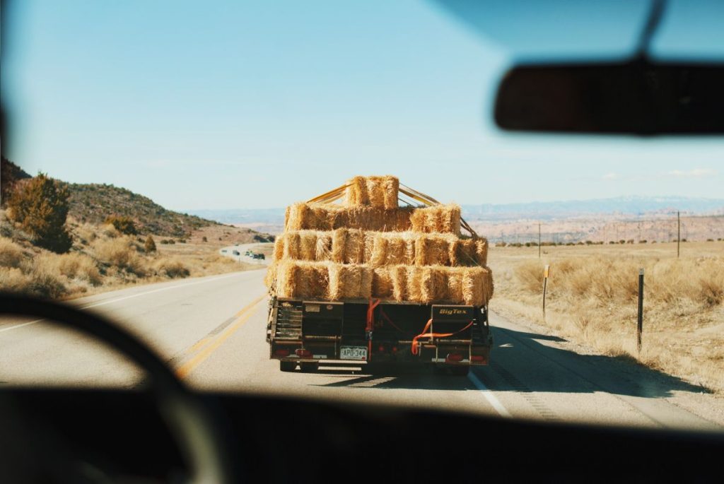 Truck carrying load of hay on highway